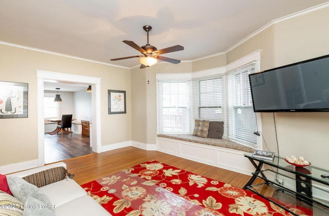 living room with ceiling fan, a healthy amount of sunlight, ornamental molding, and hardwood / wood-style floors