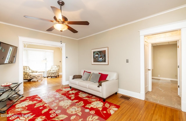 living room with crown molding, ceiling fan, and hardwood / wood-style floors