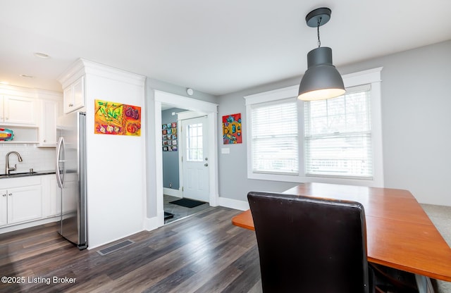 dining room with dark hardwood / wood-style flooring and sink