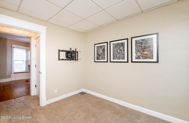 spare room featuring carpet flooring and a paneled ceiling