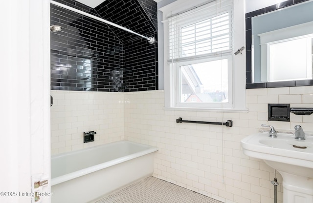 bathroom with tile patterned flooring, sink, tile walls, and shower / bathing tub combination