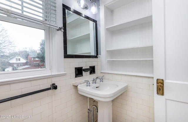 bathroom with sink and tile walls