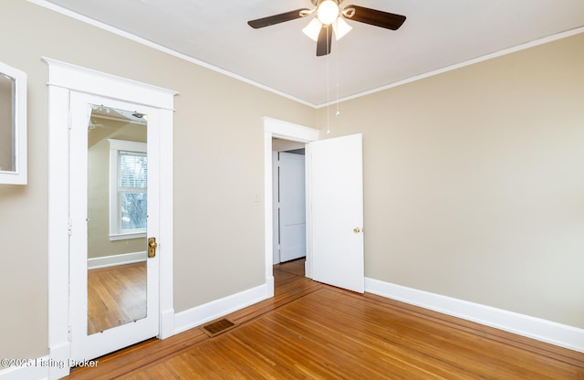 unfurnished bedroom with ornamental molding, hardwood / wood-style floors, and ceiling fan