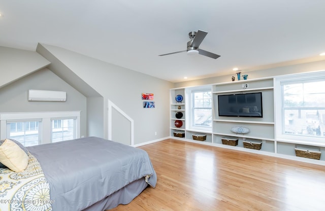 bedroom featuring ceiling fan, wood-type flooring, and a wall unit AC