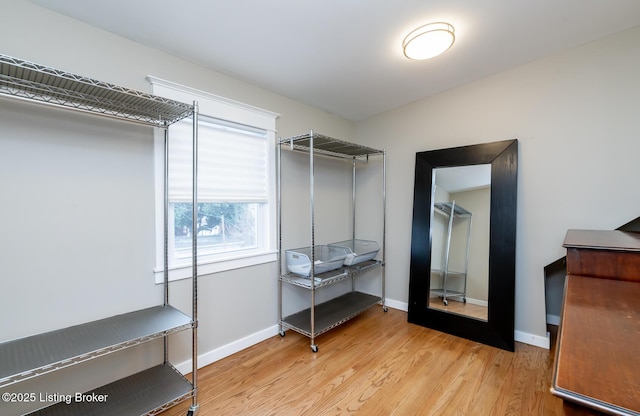 walk in closet with light hardwood / wood-style floors