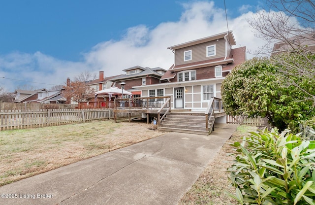 view of front facade featuring a deck and a front lawn