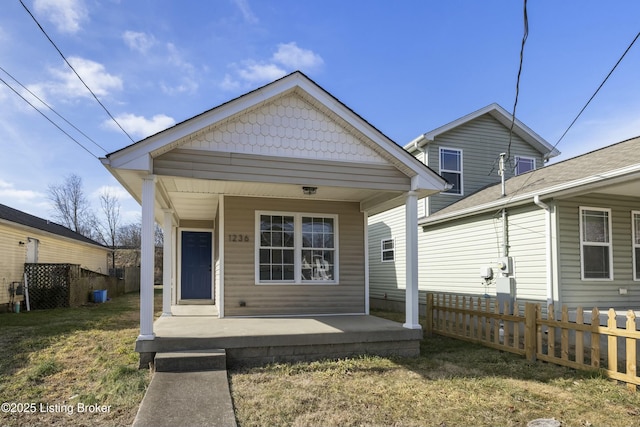 back of house with a porch and a lawn