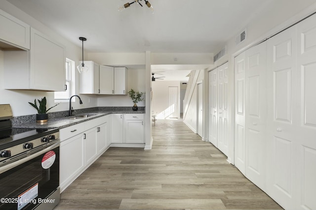 kitchen with white cabinetry, stainless steel electric range oven, sink, and pendant lighting