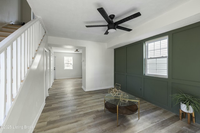 living room featuring wood-type flooring and ceiling fan