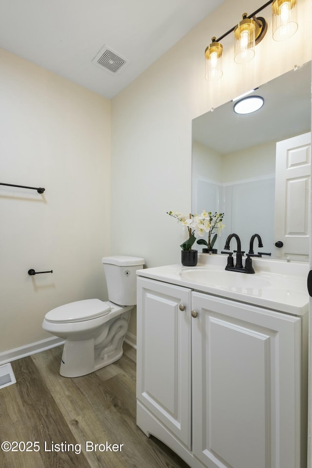 bathroom featuring vanity, hardwood / wood-style floors, and toilet