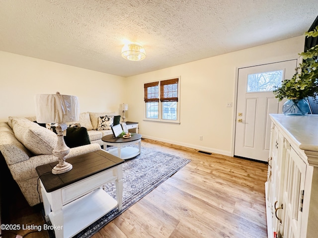 living room featuring a textured ceiling and light hardwood / wood-style floors