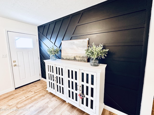 entrance foyer with hardwood / wood-style floors and a textured ceiling