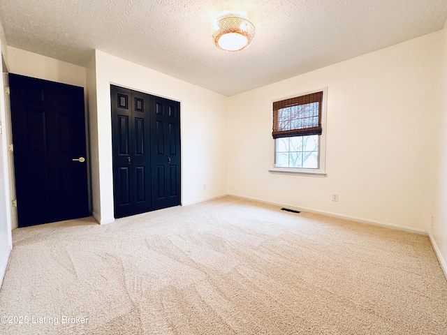 unfurnished bedroom with carpet floors and a textured ceiling