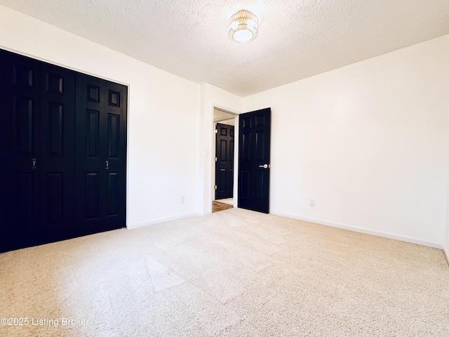 unfurnished bedroom featuring carpet flooring, a closet, and a textured ceiling