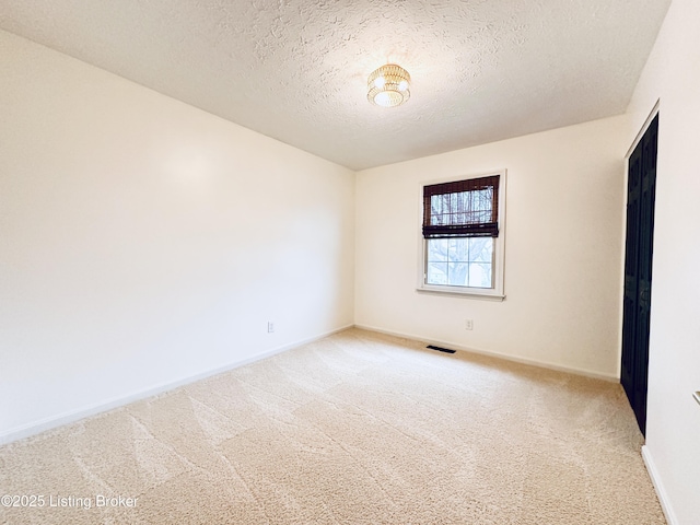 carpeted spare room with a textured ceiling