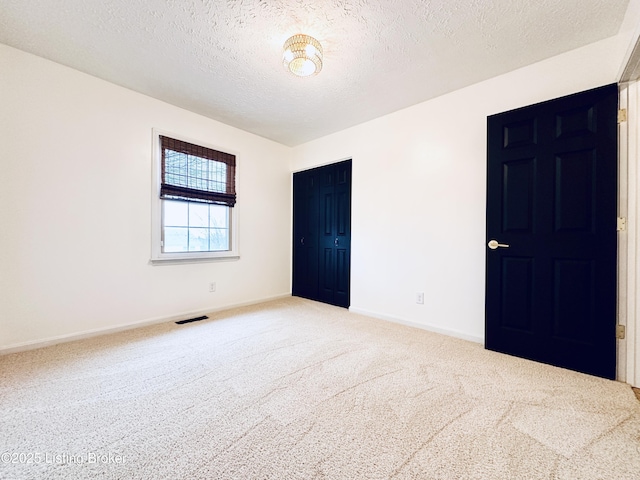 empty room featuring carpet floors and a textured ceiling