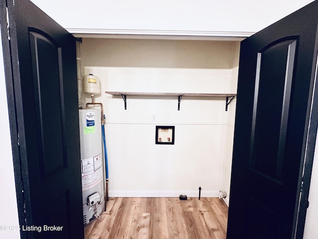 washroom featuring gas water heater, washer hookup, and light wood-type flooring