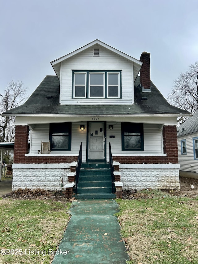 view of front of home with a porch and a front lawn