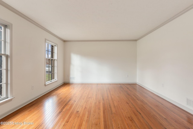 spare room with ornamental molding, wood finished floors, and baseboards