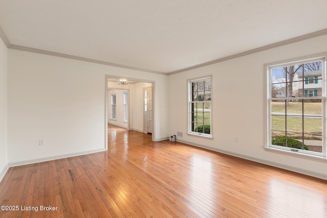 unfurnished room featuring crown molding, light wood-type flooring, and plenty of natural light