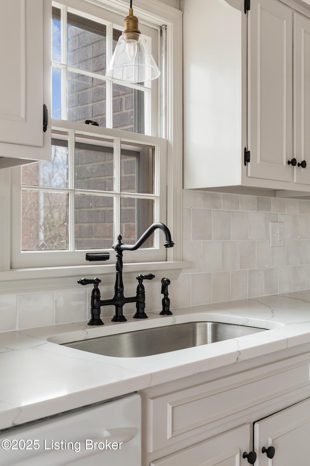 kitchen featuring white cabinetry, plenty of natural light, and dishwashing machine