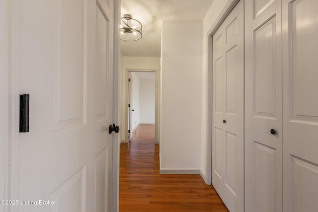 corridor with wood finished floors and baseboards