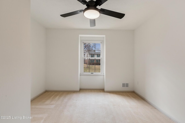 empty room featuring baseboards, visible vents, and light colored carpet