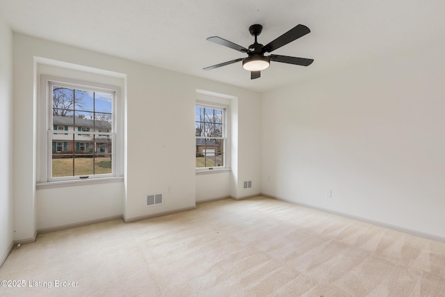 unfurnished room featuring light carpet, plenty of natural light, and visible vents