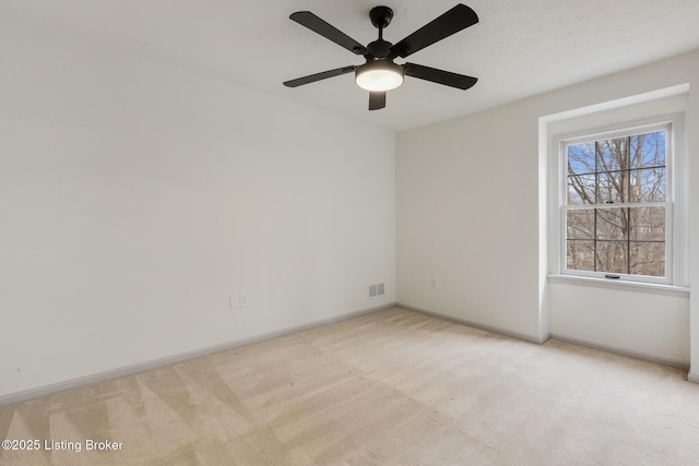 spare room with light carpet, visible vents, and baseboards