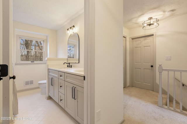 full bath with visible vents, a sink, toilet, and double vanity