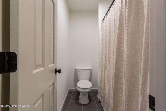 full bath with tile patterned flooring, toilet, and baseboards