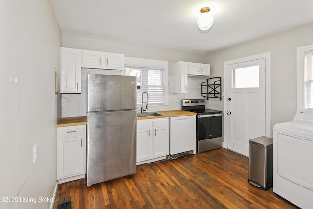 kitchen featuring washer / dryer, sink, butcher block countertops, white cabinetry, and stainless steel appliances