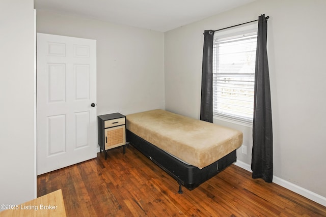 bedroom with dark hardwood / wood-style flooring