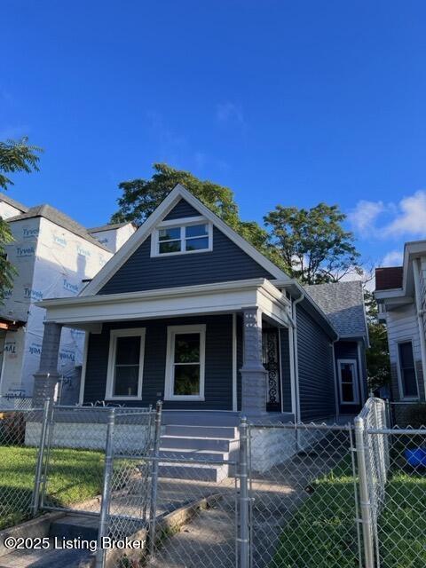 bungalow-style house with a fenced front yard, a gate, and a porch