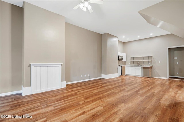 2715 W Market St, Louisville, KY 40212 - unfurnished living room with radiator, light wood-style floors, ceiling fan, and recessed lighting