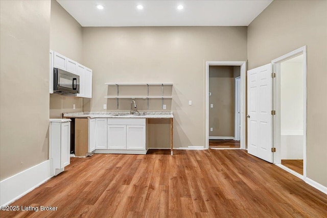 2715 W Market St, Louisville, KY 40212 - kitchen featuring black microwave, light wood finished floors, light countertops, white cabinets, and recessed lighting