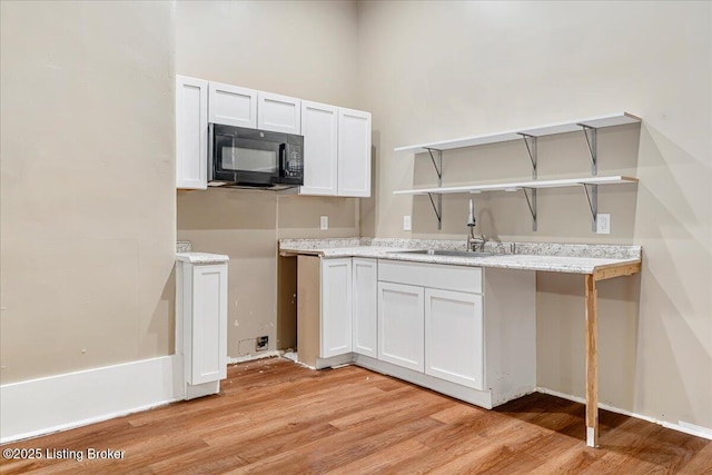 2715 W Market St, Louisville, KY 40212 - kitchen featuring black microwave, open shelves, light wood finished floors, and light countertops