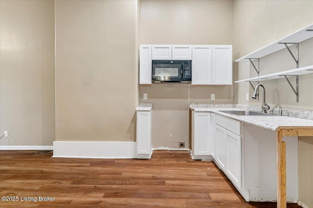 2715 W Market St, Louisville, KY 40212 - kitchen with black microwave, open shelves, light wood finished floors, and white cabinetry