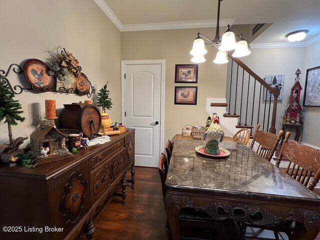 dining room featuring an inviting chandelier, ornamental molding, and dark hardwood / wood-style floors