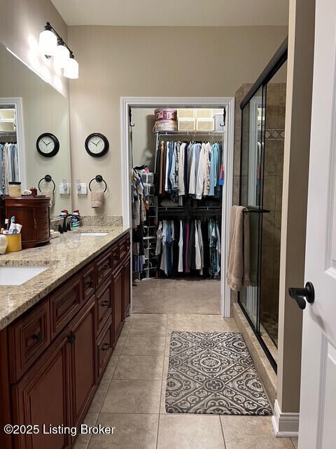 bathroom with vanity, a shower with shower door, and tile patterned floors