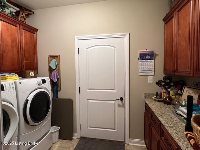 clothes washing area featuring cabinets and separate washer and dryer