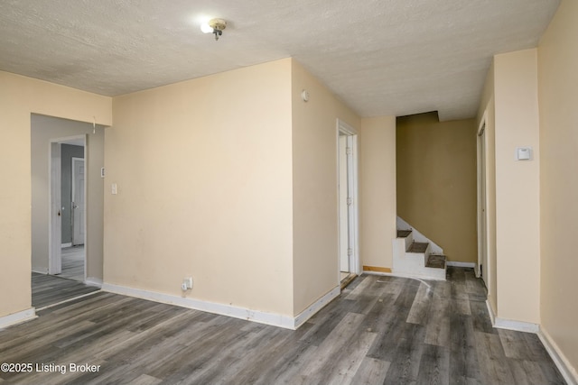 hall with dark hardwood / wood-style floors and a textured ceiling