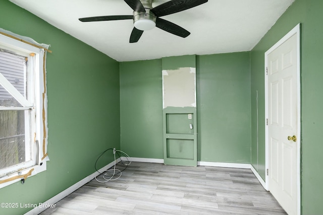 empty room with ceiling fan and light hardwood / wood-style floors