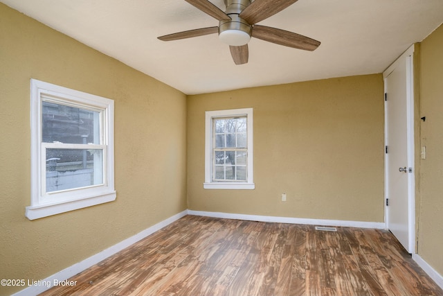 empty room with dark wood-type flooring and ceiling fan