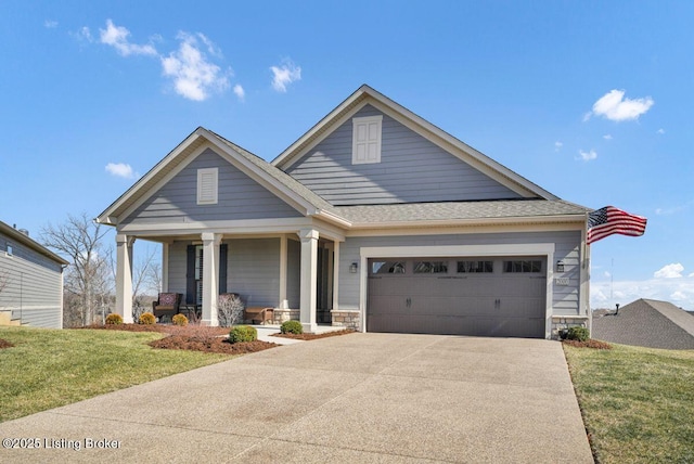 craftsman-style house featuring a front lawn, a porch, driveway, stone siding, and an attached garage