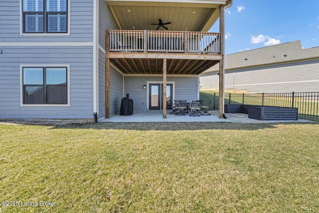 rear view of property featuring a lawn, a ceiling fan, a patio, and fence