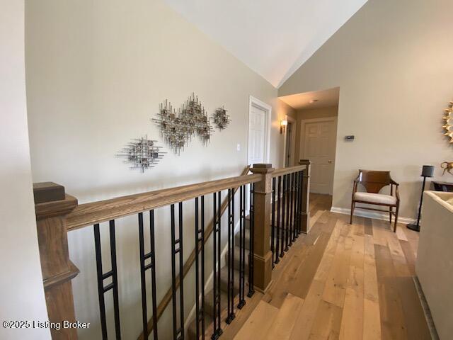 hall featuring high vaulted ceiling and light wood-type flooring