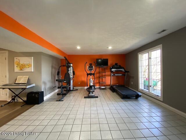 exercise room with light tile patterned floors