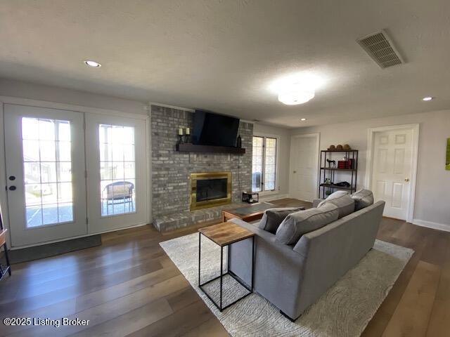 living room featuring dark wood-type flooring and a fireplace