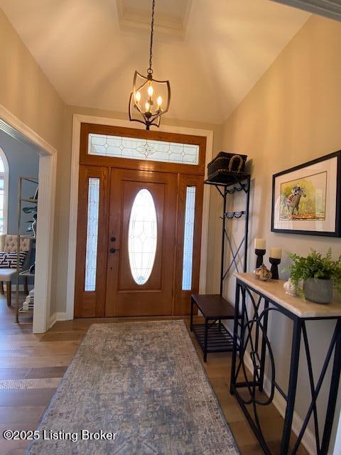 entrance foyer featuring vaulted ceiling and dark hardwood / wood-style flooring